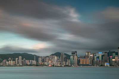 Sea by buildings against sky in city