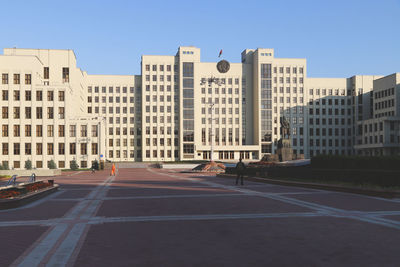 Road by buildings against sky in city