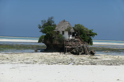 Built structure on beach against clear sky