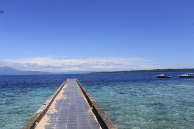 Pier over sea against blue sky