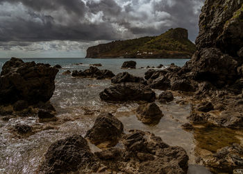 Rocks on beach against sky