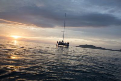 Boats in sea at sunset