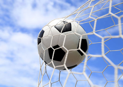 Soccer ball hitting in goal post against blue sky