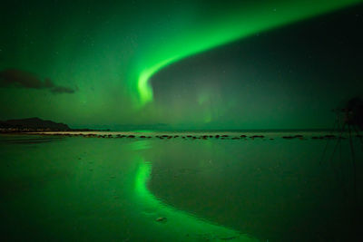 Scenic view of aurora borealis in sky over sea at night