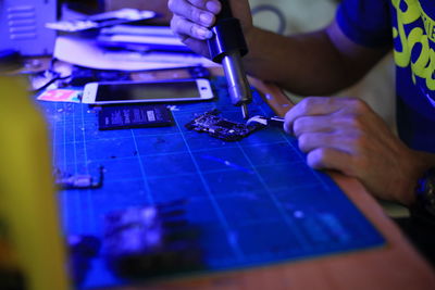 Midsection of man working on circuit board