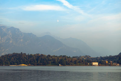 Scenic view of lake by mountains against sky