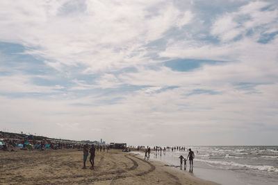 People at beach against sky