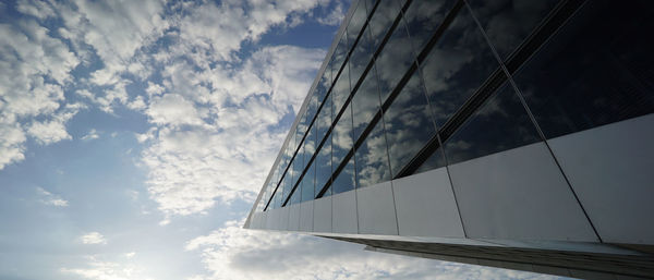 Low angle view of glass building against sky