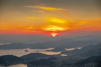 Scenic view of dramatic sky over silhouette landscape during sunset