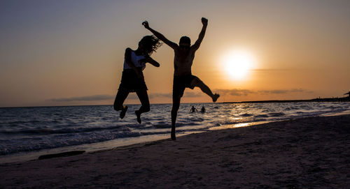 People at beach during sunset