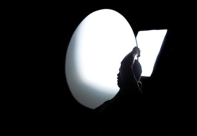 Low angle view of silhouette man against black background