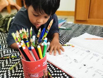 Full length of boy writing in book at home