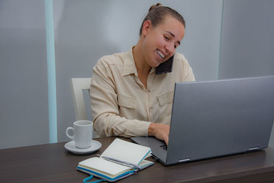 Man using mobile phone while sitting on table