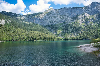 Scenic view of lake by mountains against sky