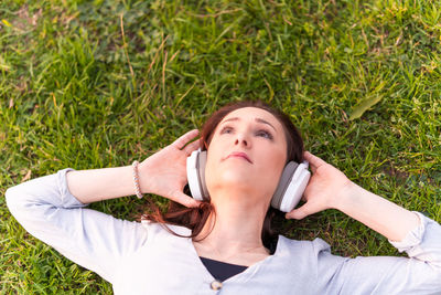 Portrait of young woman lying on grass