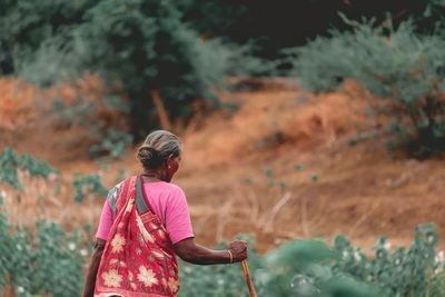 Rear view of woman standing against blurred background