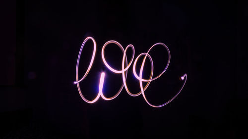 Illuminated light painting against black background