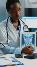 Doctor wearing mask showing medical tablet