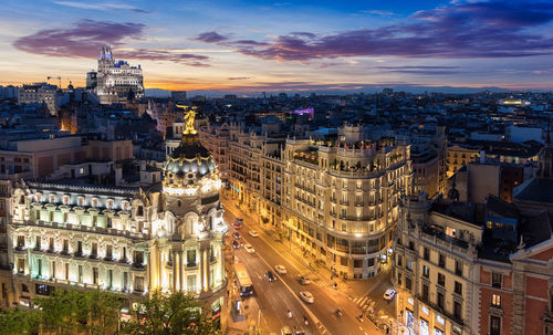 High angle view of gran via amidst buildings during sunset in city