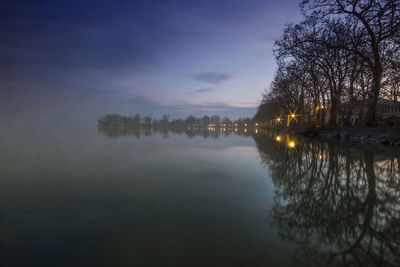 Scenic view of lake against sky at sunset