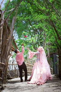 Friends standing on pink tree by plants