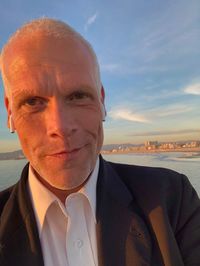 Close-up portrait of man against sea and sky during sunset