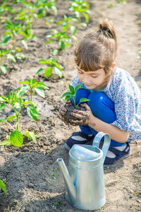 Side view of boy watering plants