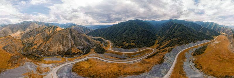 Stunning landscape of high mountains, highway, coniferous forest 