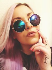 Close-up of young woman with purple hair wearing sunglasses