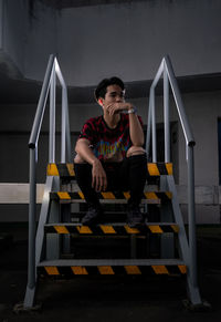 Portrait of young man sitting on staircase