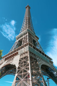 Close up angle of the eiffel towe in france while workers are maintaining the frame