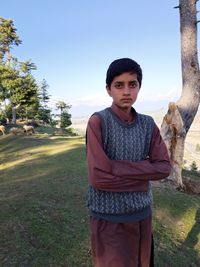 Portrait of young man standing on field