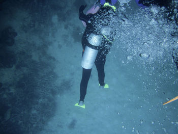 Low section of man scuba diving undersea