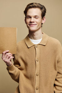 Portrait of young man standing against wall