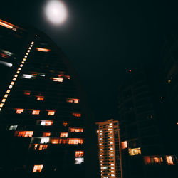 Low angle view of illuminated lights in city at night