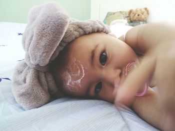 Portrait of cute baby lying on bed at home