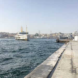 Ship moored at harbor against clear sky