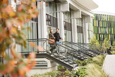 Smiling couple leaving house with bicycles