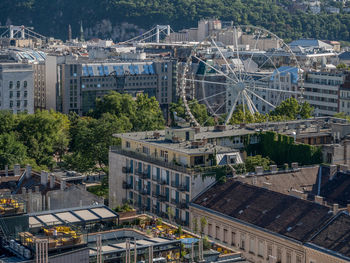 High angle view of ferris wheel and buildings in city