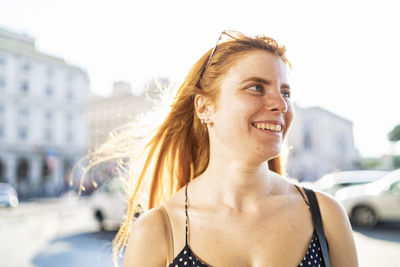 Happy ginger woman on city street