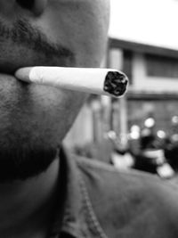 Close-up of man smoking cigarette on road