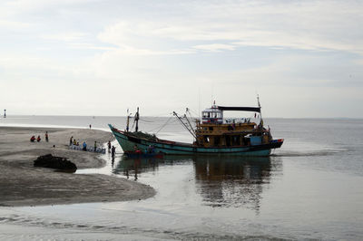 Ship moored on sea against sky