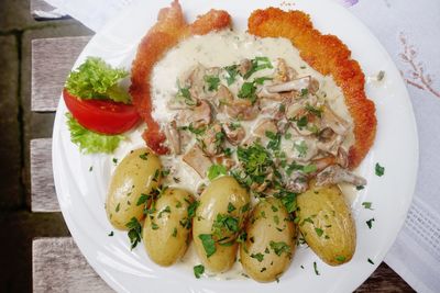 High angle view of schnitzel with potatoes served in plate on table