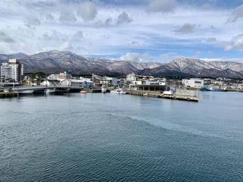 Scenic view of sea by buildings against sky