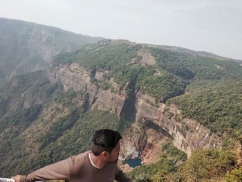 Man looking at mountains against sky