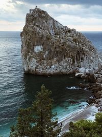 Scenic view of rock formation in sea against sky