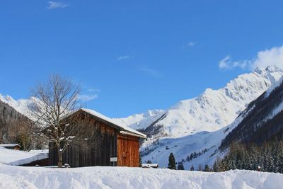 Scenic view of snow covered mountains against cloudy sky