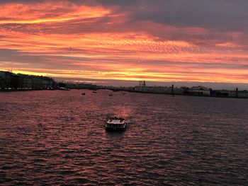 Boat sailing in sea against sky during sunset