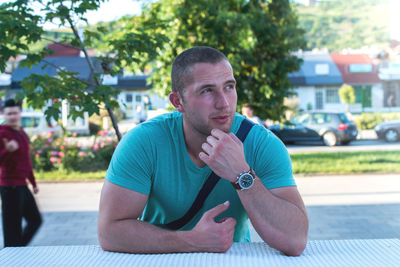 Young man drinking water while sitting in swimming pool