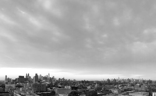 Cityscape against cloudy sky